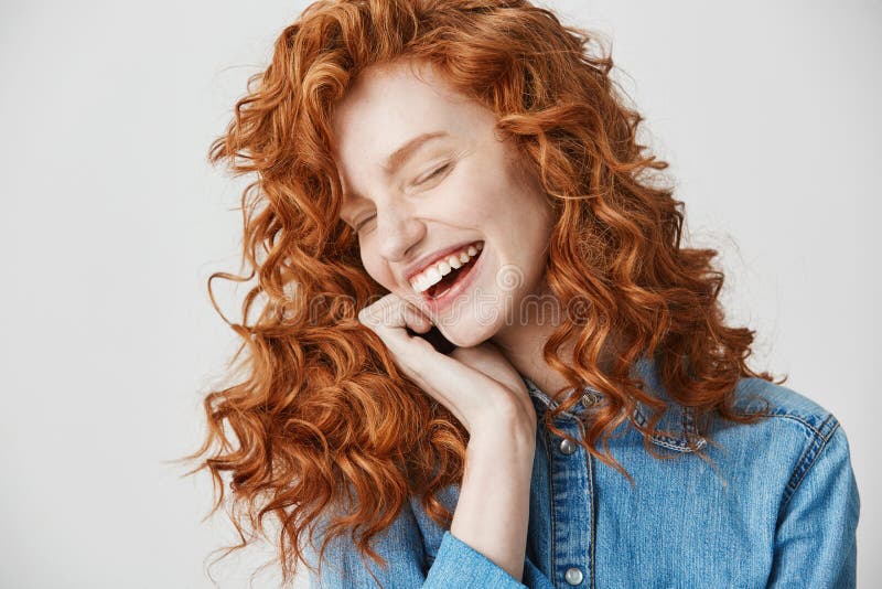 Portrait of beautiful cute ginger girl laughing smiling with closed eyes over white background.