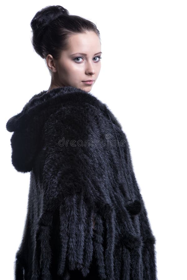 Woman in luxury black color fur coat looking back