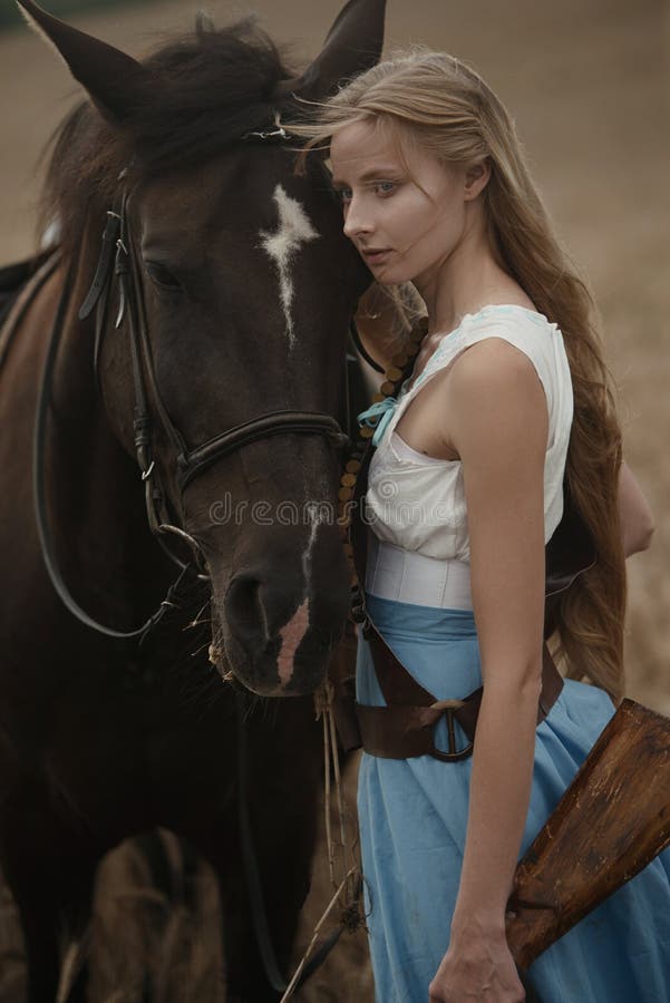 Portrait of a beautiful female cowgirl with shotgun from wild west riding a horse in the outback. stock photography Portrait of a beautiful female cowgirl with shotgun from wild west riding a horse in the outback. stock photography