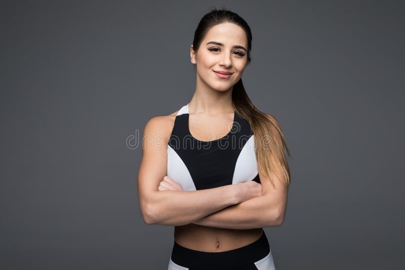 Muscular sporty lady posing with arms crossed Stock Photo by