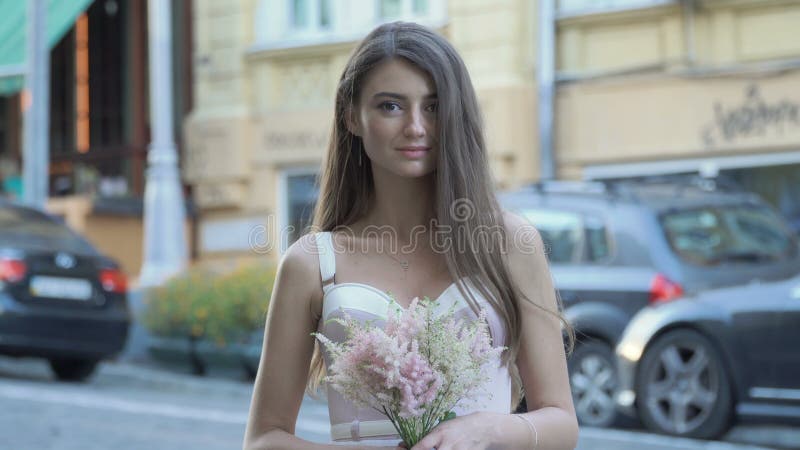 Beautiful girl with flowers near blurred road