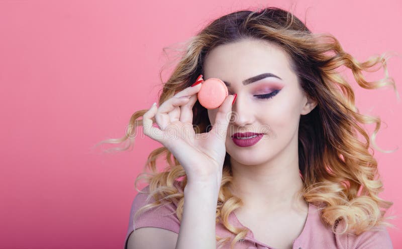 Portrait of a beautiful girl with macaroon in hands on a bright color background, concept of advertising food, diet, sweets royalty free stock image Portrait of a beautiful girl with macaroon in hands on a bright color background, concept of advertising food, diet, sweets royalty free stock image