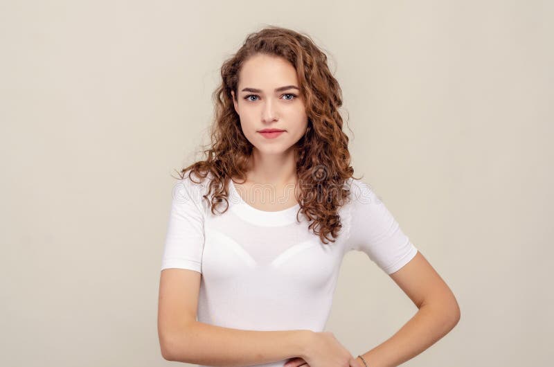 Portrait of beautiful girl standing isolated over yellow background, looking directly at camera, seductive looking