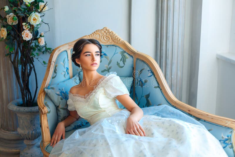 Portrait of a beautiful girl who reads a book on a sofa in a beautiful dress stock images Portrait of a beautiful girl who reads a book on a sofa in a beautiful dress stock images