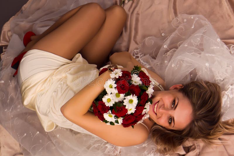 Portrait of a beautiful happy bride lying