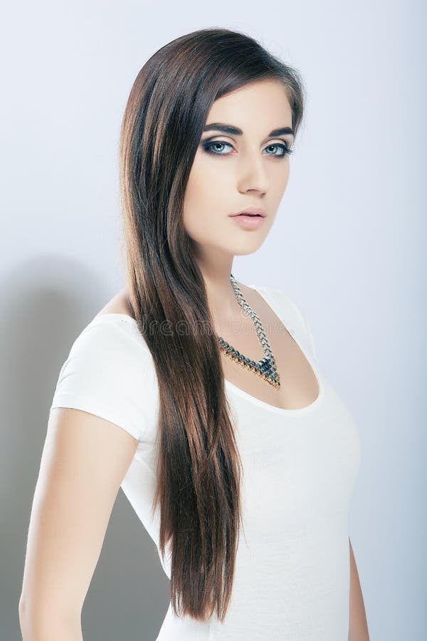 Portrait beautiful high key girl with long hair, blue eyes. Brunette, caucasian.