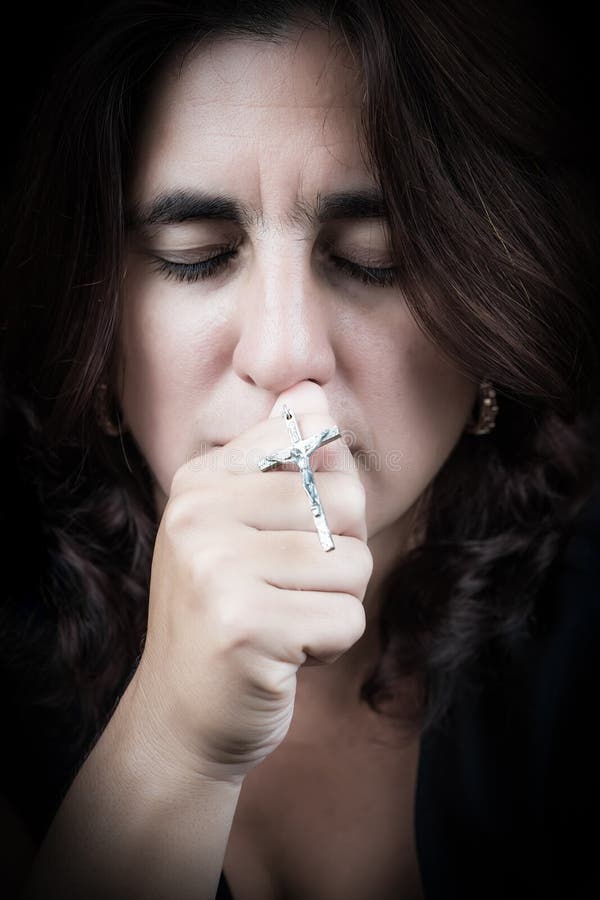 Portrait of a beautiful latin woman kissing a crucifix stock image Portrait of a beautiful latin woman kissing a crucifix stock image