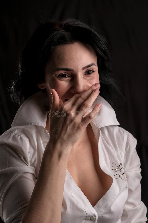 Portrait Of Beautiful Mature Brunette Woman Dressed In White Shirt Isolated On Black Background