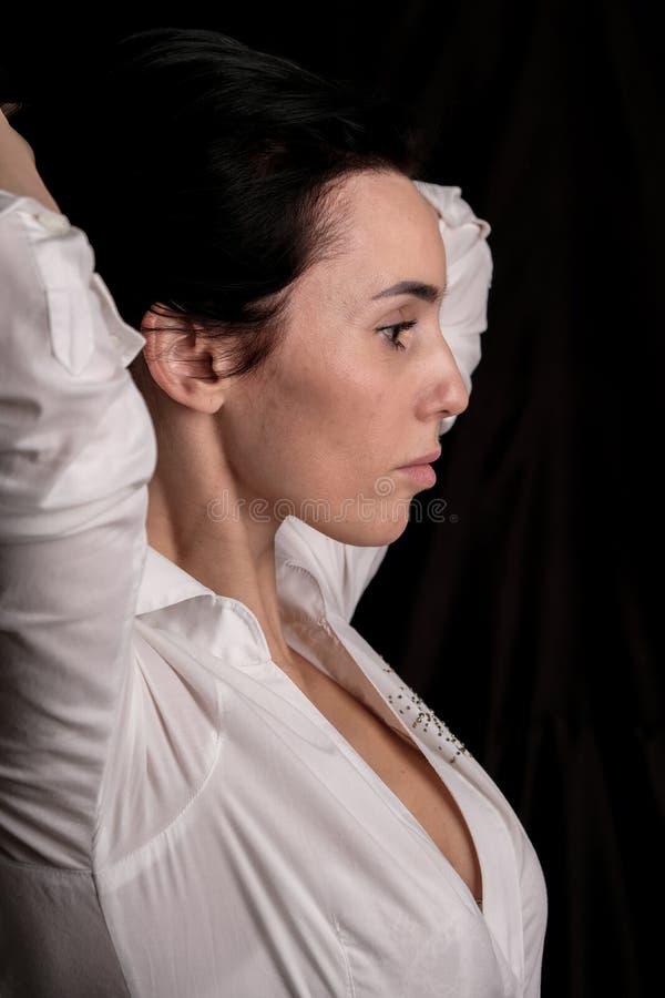 Portrait Of Beautiful Mature Brunette Woman Dressed In White Shirt Isolated On Black Background