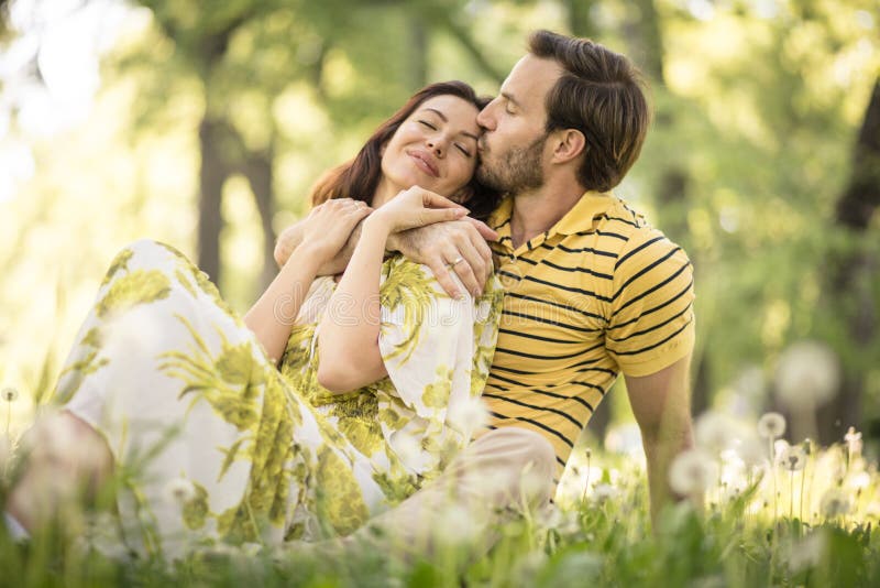 Portrait of beautiful middle age couple sitting at nature.