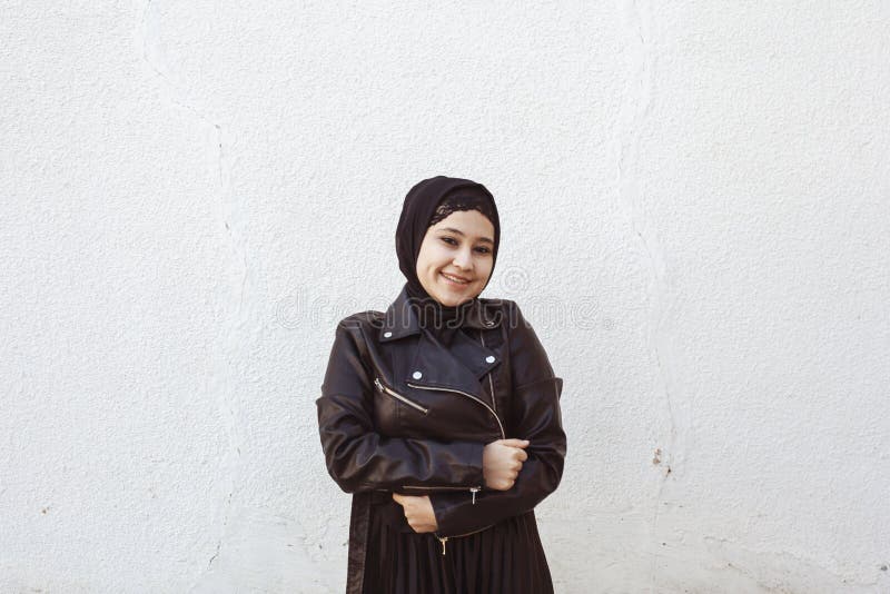 Portrait of beautiful middle-eastern girl in traditional Islamic clothing - hijab. Modern and young Iranian woman in leather