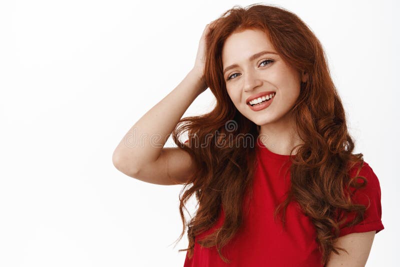 Portrait Of Beautiful Natural Redhead Girl With Curly Hair Touching Head And Smiling Happy