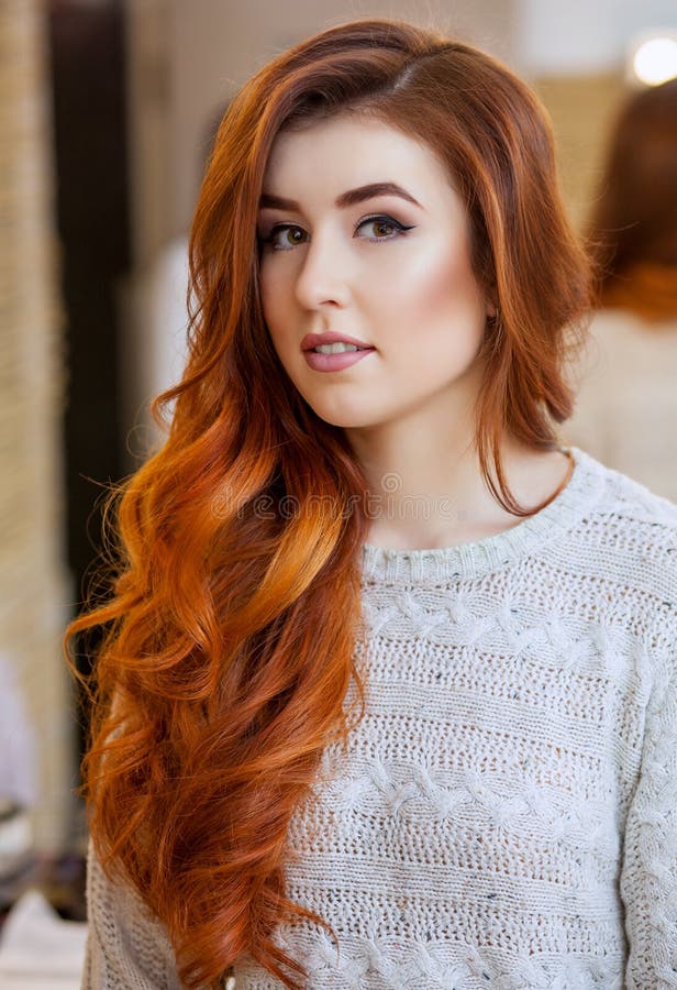 Portrait of a beautiful, red-haired girl with long hair in a beauty salon.