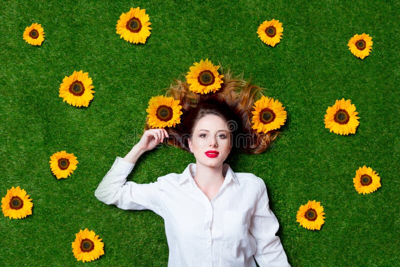 Portrait of beautiful red-haired girl with sunflowers