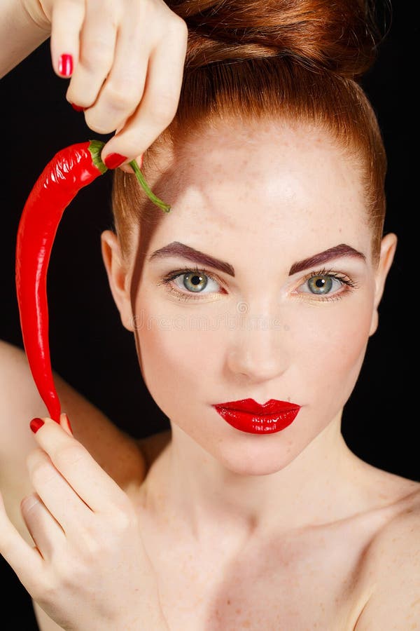 Portrait of beautiful red-haired woman with red hot spicy cayenne chili pepper stock image Portrait of beautiful red-haired woman with red hot spicy cayenne chili pepper stock image
