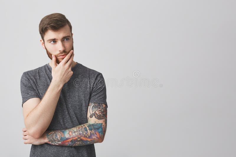 Portrait of Beautiful Serious European Man with Beard and Tattoo on Arm Holding Hand in Face, Looking Aside with Stock Image - Image of headacke, face: 103247941 Portrait of Beautiful Serious European Man with Beard and Tattoo on Arm Holding Hand in Face, Looking Aside with Stock Image - Image of headacke, face: 103247941