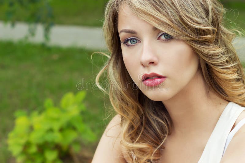 Portrait of beautiful blonde girl in a Park with large plump lips