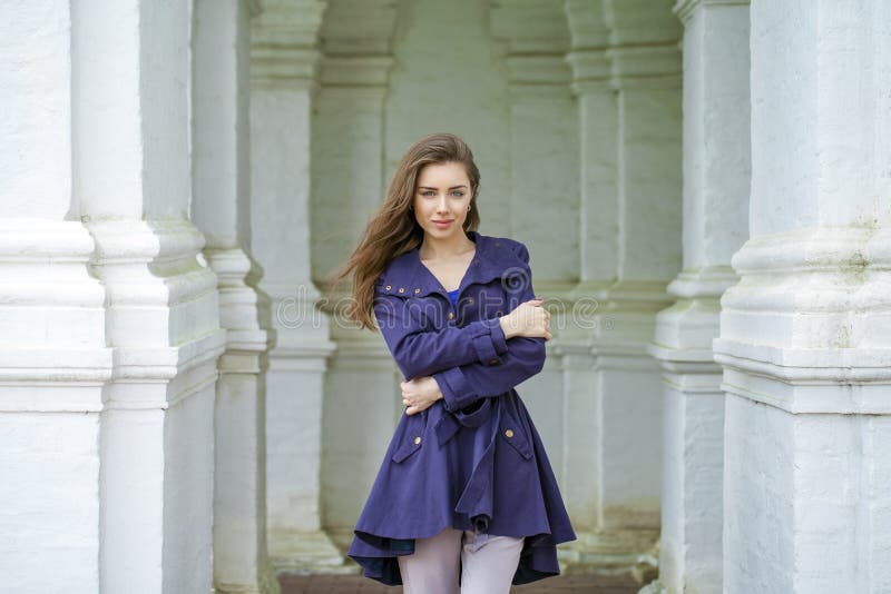 Portrait of a beautiful young woman in dark blue coat