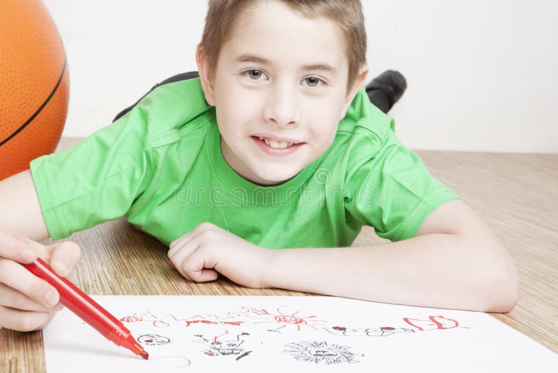 Portrait of beautiful smiling boy drawing