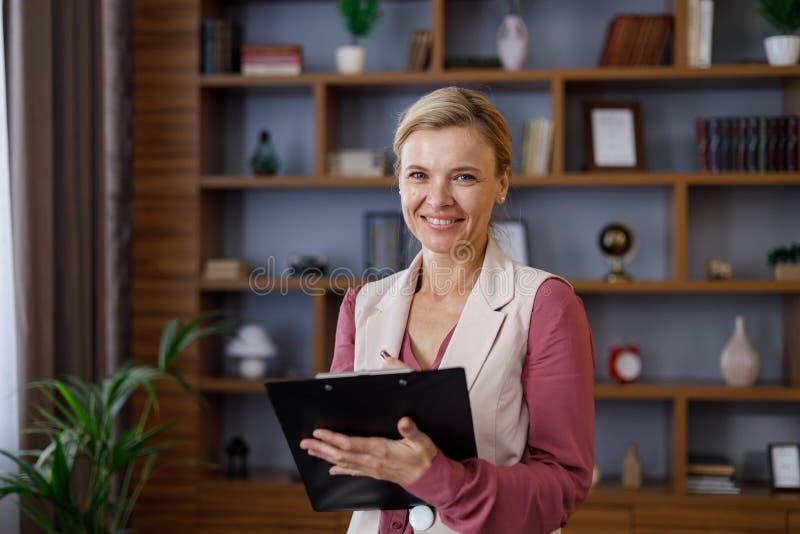 Portrait Of Beautiful Smiling Female Psychologist Taking Notes On Clipboard Professional