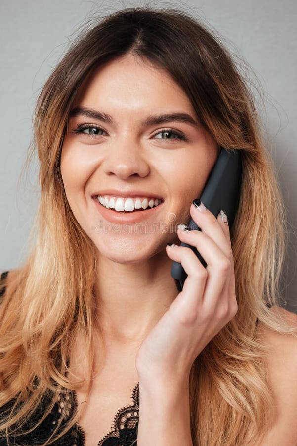 Portrait of a beautiful smiling girl talking on mobile phone