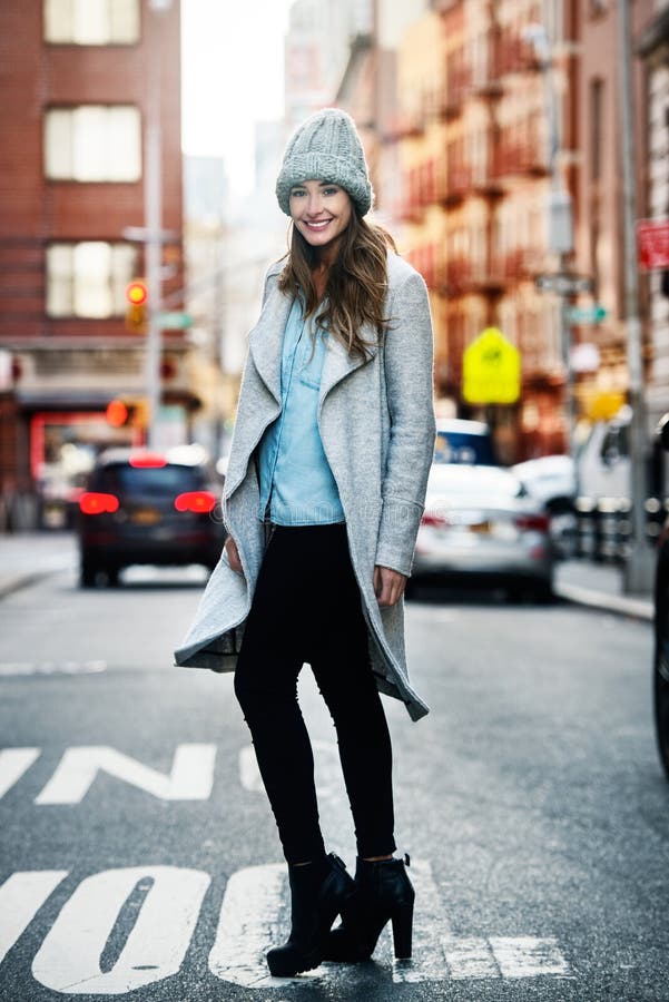 Portrait of beautiful smiling woman walking on city street