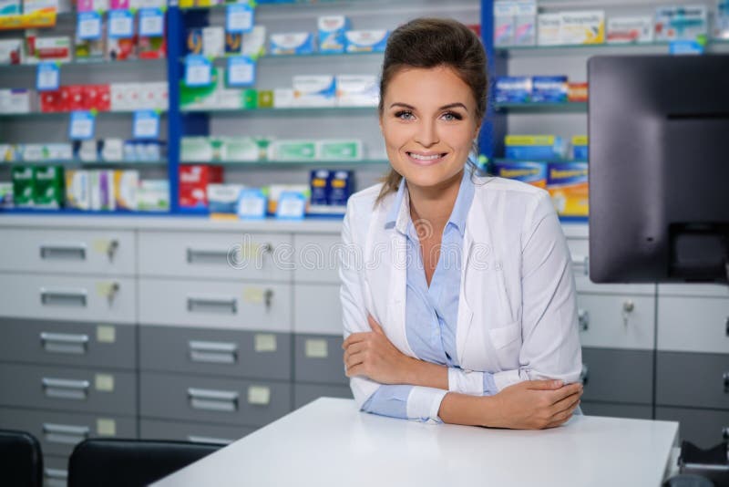 Portrait of beautiful smiling young woman pharmacist standing in pharmacy.