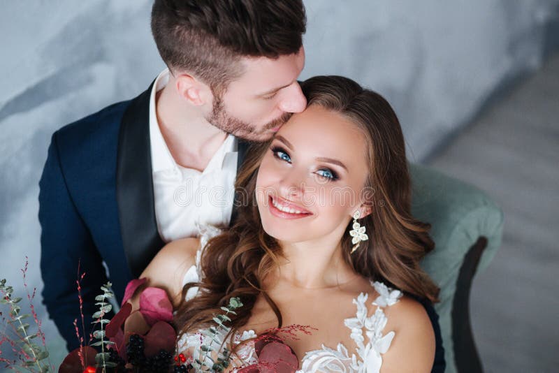 Portrait of beautiful wedding couple together. Bride and groom kiss and hug each other