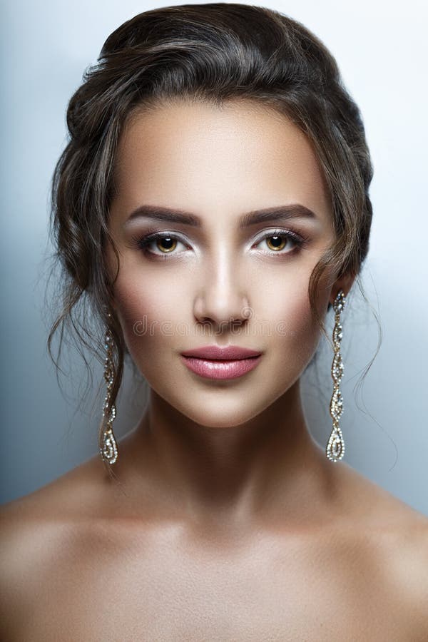 Portrait of a beautiful woman closeup. Perfect clean skin, beautiful hair, professional makeup. Stylish jewelry royalty free stock photo Portrait of a beautiful woman closeup. Perfect clean skin, beautiful hair, professional makeup. Stylish jewelry royalty free stock photo