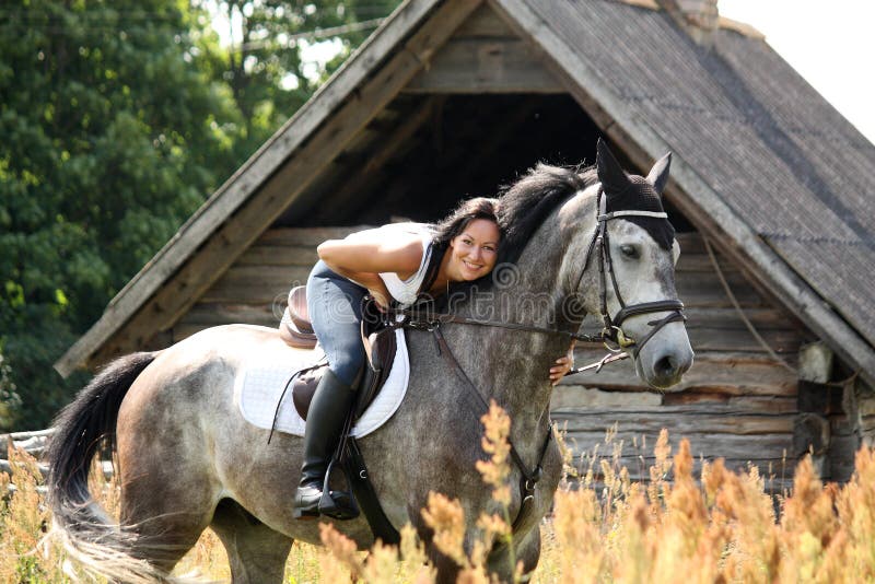 Portrait of beautiful woman on horse near the barn stock photos Portrait of beautiful woman on horse near the barn stock photos