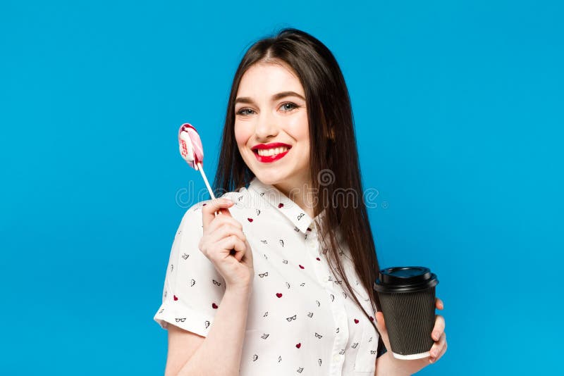 Portrait of beautiful woman with lolly isolated on blue background. Portrait of beautiful brunette girl with red