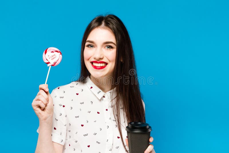 Portrait of beautiful woman with lolly isolated on blue background. Portrait of beautiful brunette girl with red