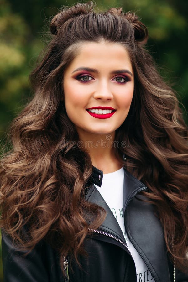 Beautiful woman with long curly hair in leather jacket.