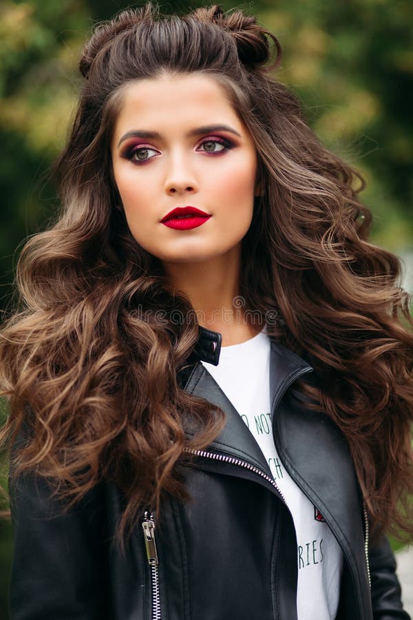 Beautiful woman with long curly hair in leather jacket.