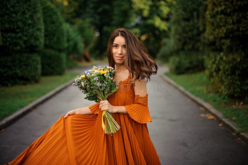 Portrait of beautiful woman in long orange dress stock photos Portrait of beautiful woman in long orange dress stock photos