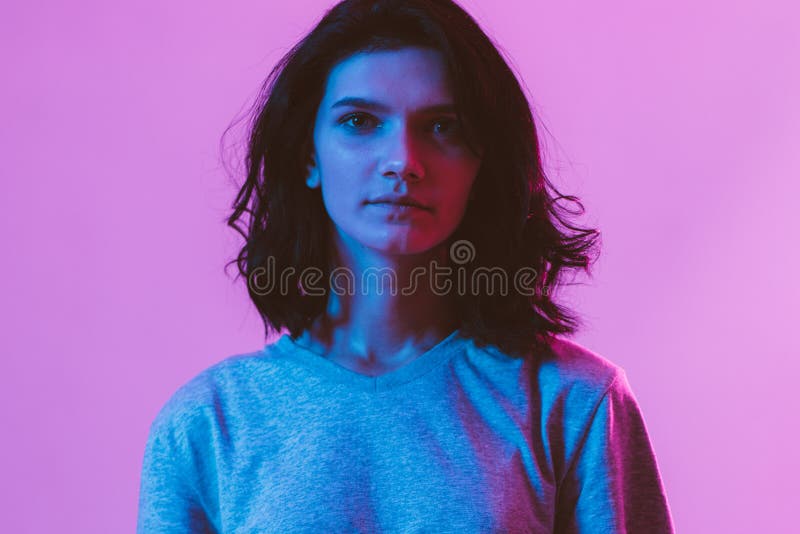 Portrait of beautiful woman. Pink, purple and blue light colors.