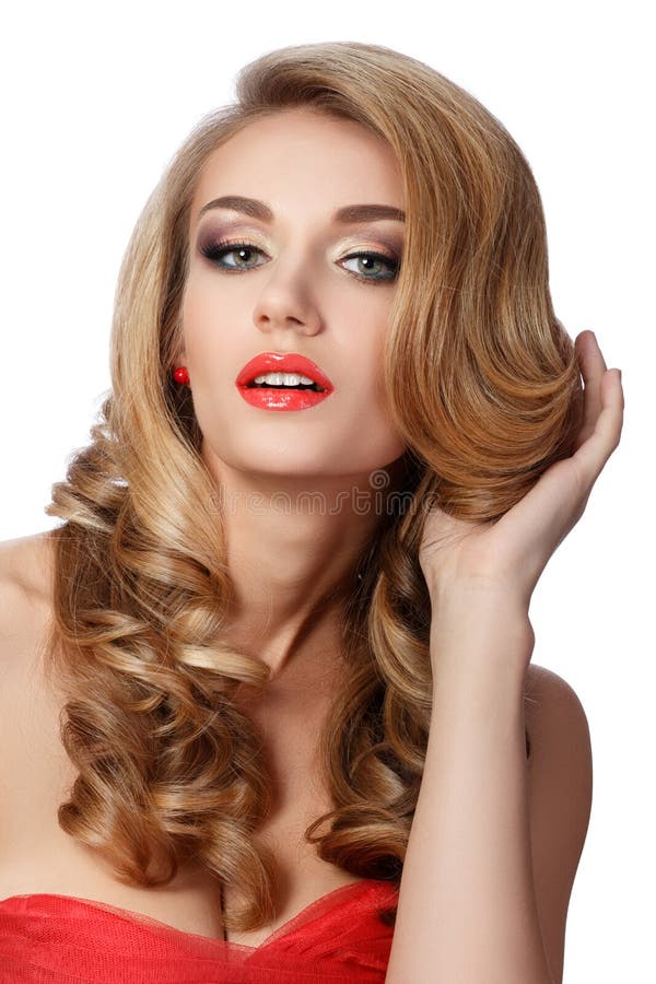 Portrait of beautiful woman in red dress doing up her hair