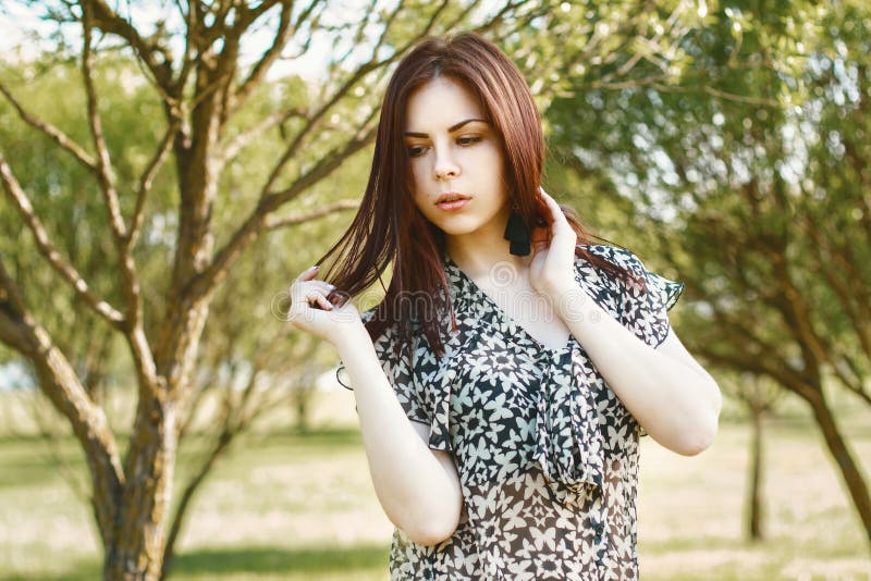 Portrait of a beautiful woman in spring park with small trees. stock image Portrait of a beautiful woman in spring park with small trees. stock image