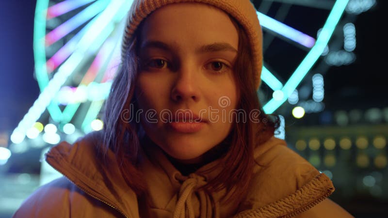 Beautiful woman looking camera on urban street. Girl posing in night city.