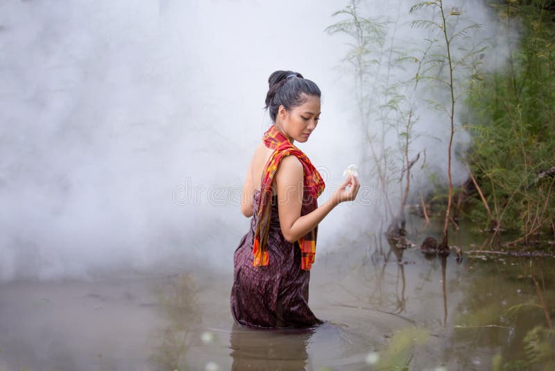 Portrait of beautiful young Asian woman bathing in the river stock photogra...