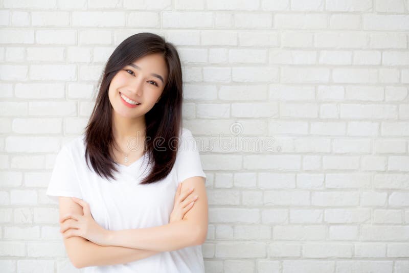 Portrait of beautiful young asian woman happiness standing on gray cement texture grunge wall brick background.