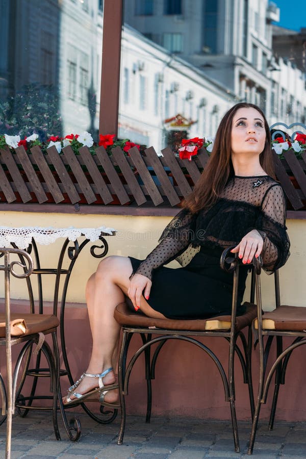 Portrait of a beautiful, young, attractive girl who sits on the street in a cafe. waiting for breakfast, summer, date. dream royalty free stock photos Portrait of a beautiful, young, attractive girl who sits on the street in a cafe. waiting for breakfast, summer, date. dream royalty free stock photos