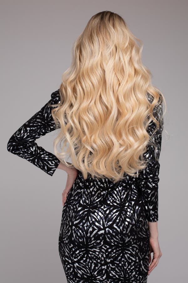 Portrait Of Beautiful Young Blond Woman With Long Wavy Hair. Back View