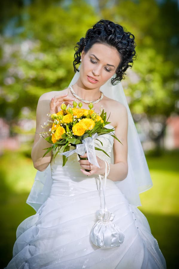 Portrait of beautiful young bride in garden