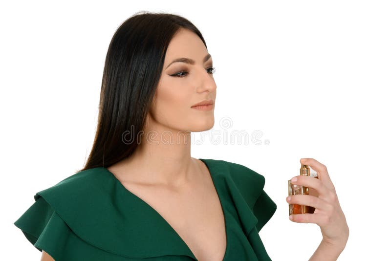 Portrait of a beautiful young female in green dress applying a perfume royalty free stock image Portrait of a beautiful young female in green dress applying a perfume royalty free stock image