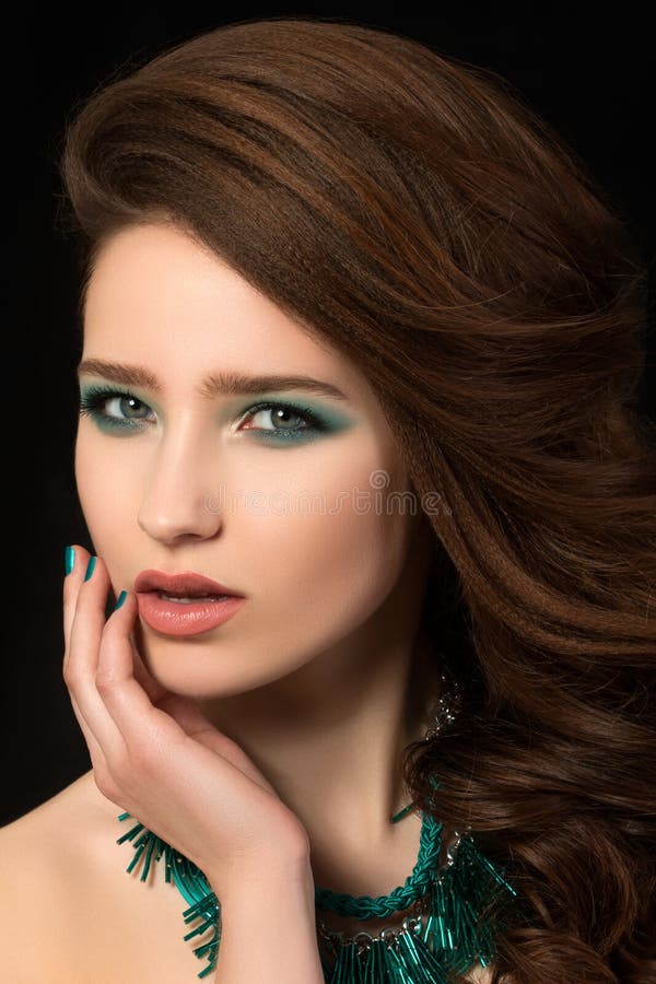 Portrait of beautiful young woman with blue nails and eye makeup