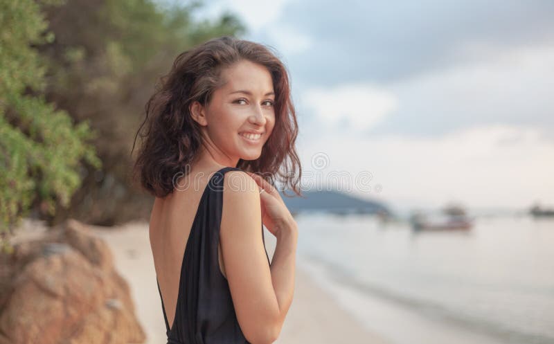 Portrait of a beautiful young woman with dark hair, on the beach, sensual portrait, natural beauty