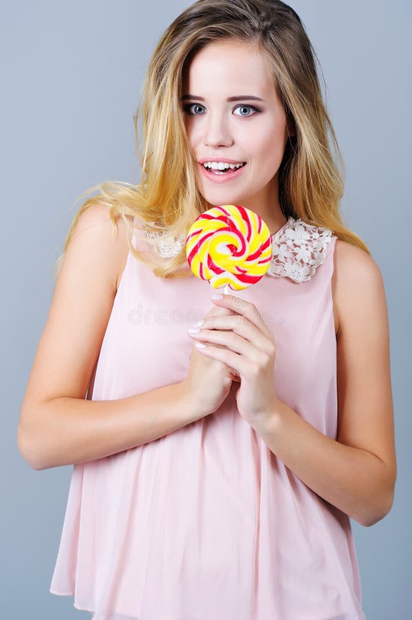 Portrait Of A Beautiful Young Woman Holding Colorful Candy Stock Image