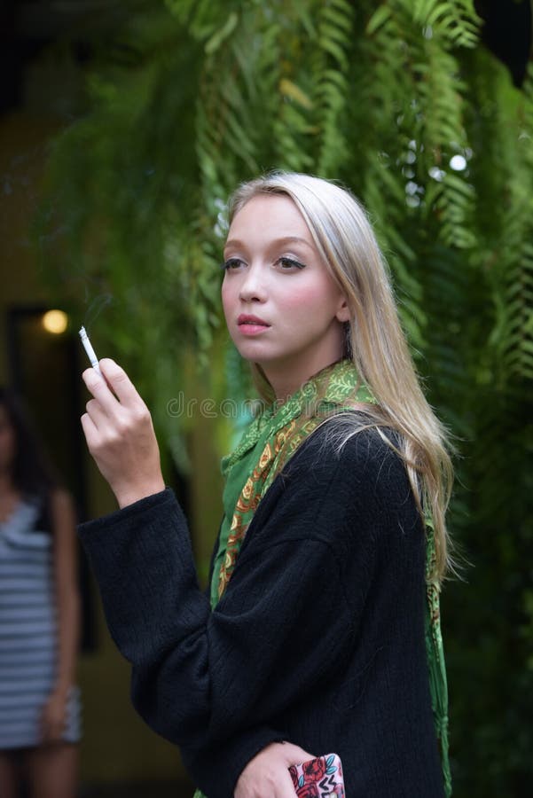 Portrait of a beautiful young woman smoking cigarettes royalty free stock photos Portrait of a beautiful young woman smoking cigarettes royalty free stock photos