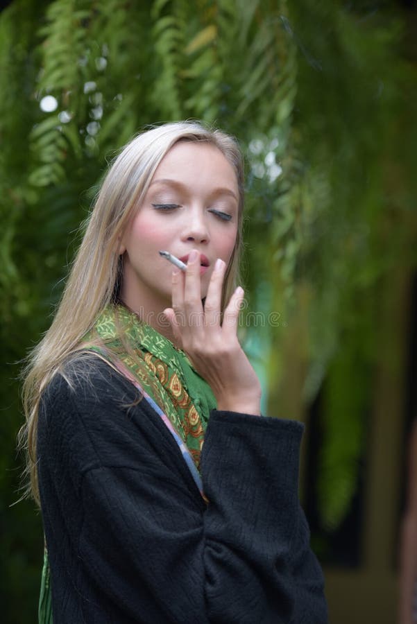 Portrait of a beautiful young woman smoking cigarettes stock photo Portrait of a beautiful young woman smoking cigarettes stock photo